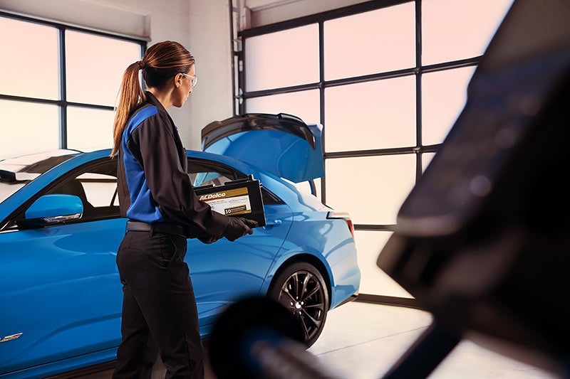 A women walking towards car with Cadillac Battery